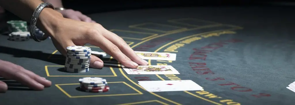 Blackjack table with cards dealt and bets made.